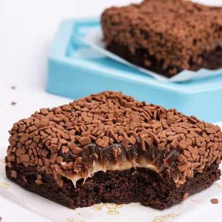 Delicioso brownie bem chocolatudo, molhadinho por dentro e crocante por fora, super recheado com brigadeiro de chocolate branco e brigadeiro de chocolate ao leite, coberto com muito granulado belga Callebaut.