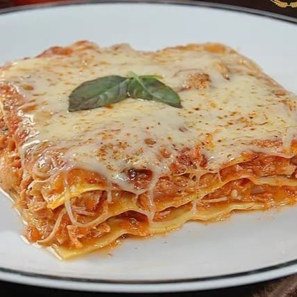 A 'Lasanha de Frango ao Pomodoro' é uma experiência gastronômica inigualável. Feita com uma massa artesanal finamente elaborada, é generosamente recheada com frango suculento ao molho pomodoro, exalando um aroma irresistível. As camadas aveludadas de queijo se fundem ao molho, intensificando os sabores. A finalização é feita com queijo gratinado, que confere à lasanha uma crosta dourada e delicios