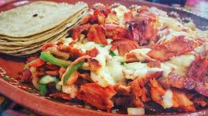 Orden de pastor acompañado de tortillas de maíz