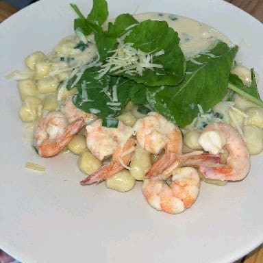 Exalando um aroma delicioso, o Inhoque de Camarão e Rúcula é uma das estrelas da categoria 'Os Queridinhos do Favelleto'. Este prato é cuidadosamente preparado com inhoque artesanal, macio e requintado, que abraça tenros camarões selecionados. O toque final fica por conta do molho branco, cremoso e aveludado, cuidadosamente derramado sobre o prato, e folhas de rúcula frescas, que adicionam uma pit