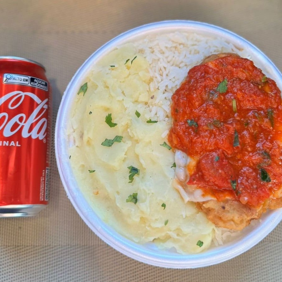 Marmita com delicioso filé de frango parmegiana (empanado na massa crocante coberto com molho de tomates e queijo) acompanhado de arroz branco e purê de batatas inglesas. Acompanha refrigerante lata Coca Cola 350ml bem gelada. Marmita indicada para 01 pessoa.