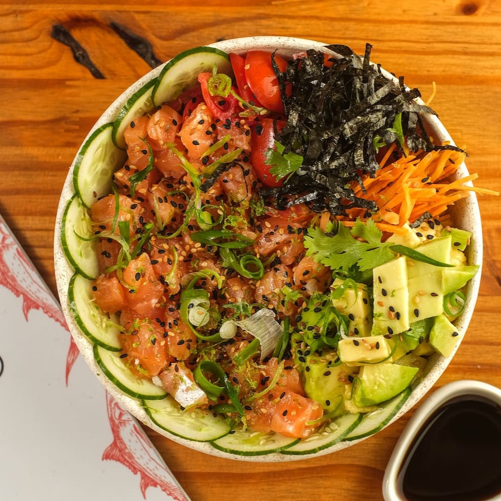 Base de arroz gohan, cubos de salmão fresco, pepino japonês, tomate cereja, abacate, cenoura, gengibre fresco, gergelim, alga nori, finalizado com cebolinha, coentro, raspas de limão taiti. Acompanha Koa molho havaiano e Koa molho teriyaki.