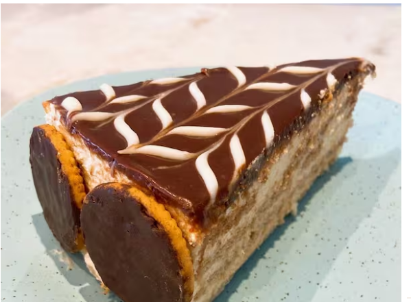 Creme de Baunilha intercalado com biscoitos maisena. Finalizado com ganashe de chocolate e decorada com biscoito tipo calipso.