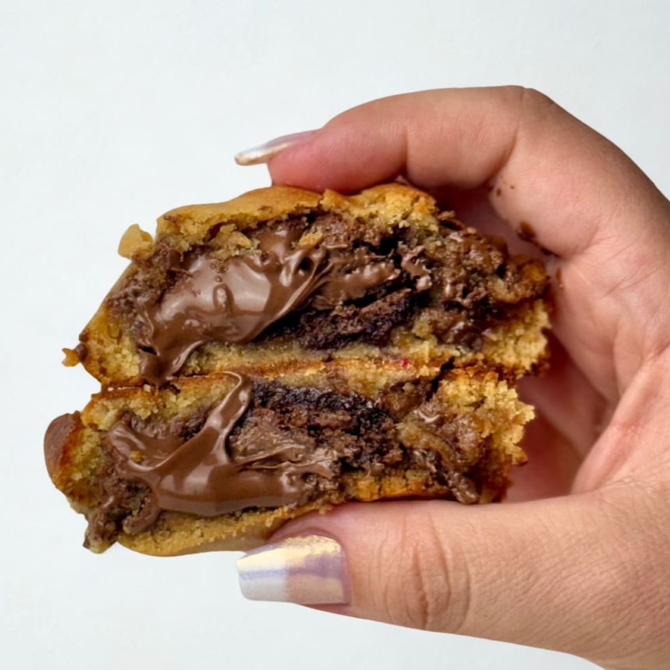 Cookie artesanal recheado com o nosso Manda Brownie, Nutella pura e gotas de chocolate nobre. Uma combinação viciante! Dica: esquente sem o plástico 20 segundinhos no microondas e coma quentinho derretendo na boca! Peso aproximado de 100g.