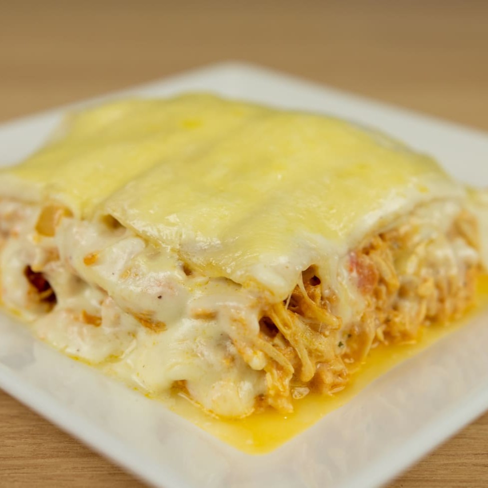 Suntuosa Lasanha de Frango aos 3 Queijos, com generosos 500g. Delicadamente preparada com uma massa artesanal de textura suave, é recheada com camadas de frango suculento e a irresistível mussarela. A envolvente cobertura leva nosso exclusivo molho de três queijos - o saboroso provolone, o intenso gorgonzola e o nobre parmesão. Para finalizar, um toque de maestria com queijo gratinado, conferindo