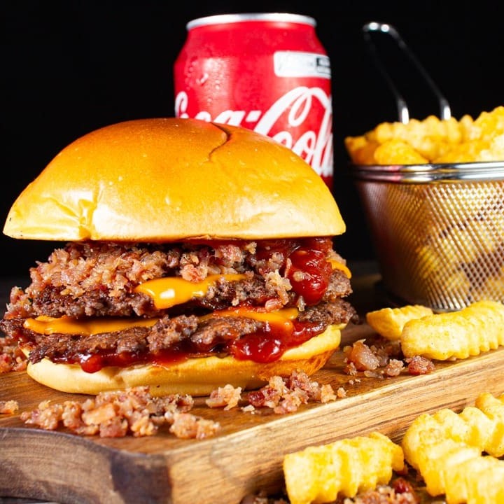 O irresistível Smash Duplo Bacon. Contendo 2x blend de 80g, delicioso cheddar em fatias, uma generosa porção de farofa de bacon artesanal finalizado no pão brioche selado na manteiga, acompanhado de batata crinkle e um refrigerante coca cola 350ml geladinho.