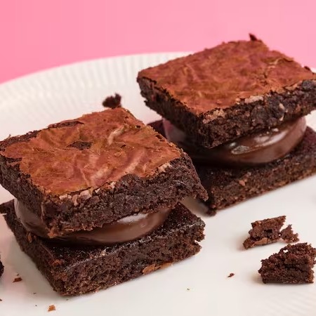 Brownie recheado bem chocolatudo, macio por dentro e crocante por fora. Tamanho 5x5 cm. Dica da Vivian Guimarães: aqueça alguns segundos no microondas para que fique Perfeito!