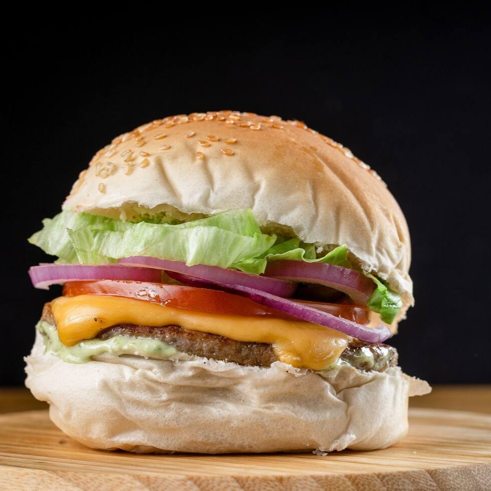 X-burguer clássico: pão macio, carne suculenta, queijo derretido, salada fresca e molho verde. Sabor popular que conquista na primeira mordida — direto ao ponto, como a cidade que nunca para.