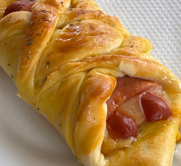 Talvez essa seja a melhor experiência de pedir lanche rápido pra resolver o dia. Nosso cachorro quente de forno é realmente fora da curva, é composto por salsicha, queijo, presunto e requeijão cremoso. Pra nunca mais parar de pedir.