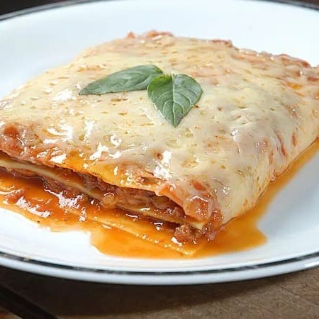 Apresentamos a nossa Lasanha Bolonhesa, parte da nossa categoria de Lasanhas Artesanais. Este prato é uma verdadeira sinfonia de sabores. A base é uma suave massa artesanal, cuidadosamente preparada para alcançar a textura perfeita. O recheio brilha com uma generosa porção de carne coberta por nosso molho pomodoro caseiro, que empresta um sabor autêntico e robusto. Camadas de queijo e presunto adi