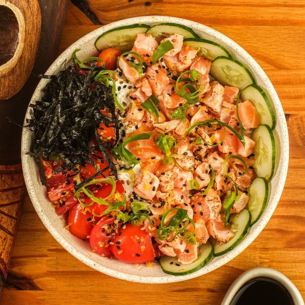 Base de arroz gohan, salmão maçaricado, azeite trufado, raspas de limão siciliano, Koa cream cheese (com nori), pepino japonês, tomate cereja, gergelim, finalizado com cebolinha e alga nori. Acompanha Koa molho havaiano.