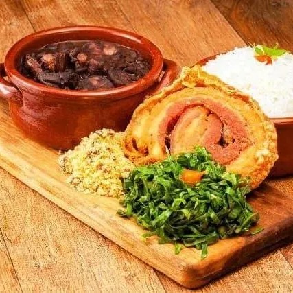 Apresentando uma Feijoada Especial Carioca Individual (500 ml), uma das mais vendidas de nossa carta. Oferecemos uma generosa porção individual, perfeita para saborear sozinho ou compartilhar com alguém especial. Nossa feijoada é meticulosamente preparada com uma seleção premium de carnes: pé, orelha, rabo, lombo suíno defumado, bacon, carne seca, calabresa e paio. Cada ingrediente é cozido lentamente, preservando o sabor e a textura. Para complementar, acompanha arroz branco soltinho, couve fresca, farofa crocante, torresmo de Rolo Crocante e laranja para equilibrar o paladar. Este prato é a celebração perfeita da autêntica culinária carioca. Tudo Separado****Não Fazemos Alterações**** 5 Acompanhamentos (Arroz, farofa, torresmo rolo, couve e laranja)
