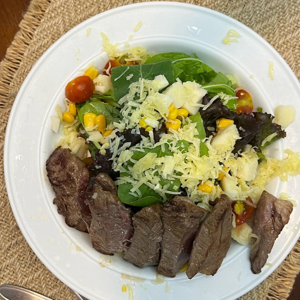 Uma deliciosa salada que combina uma mistura de folhas frescas com ingredientes sofisticados e saborosos, como palmito, milho, tomates cereja e lascas de parmesão, complementados pelo toque especial do coração de alcatra. Para realçar os sabores, você pode escolher entre dois molhos incríveis: mostarda com mel, que traz o equilíbrio perfeito entre o doce e o ácido, ou o molho pesto, feito com manj