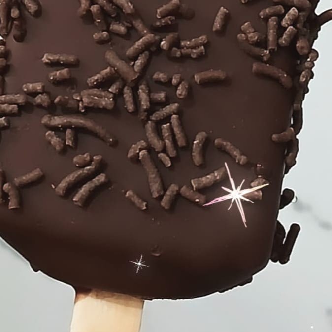 Delicioso Picolé de chocolate suíço, coberto com uma camada de chocolate e chocolate granulado (com adição de leite e derivados do leite)