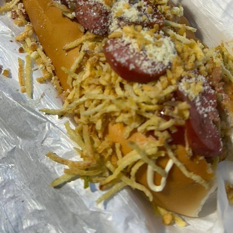 Linguiça, molho (cebola, tomate, pimentão), ketchup, molho da casa, alho frito, farofa de bacon, calabresa, milho, ervilha, azeitonas, cheddar, Catupiry, maionese temperada, , ovo de cordona, batata palha, queijo ralado e cebola crispy