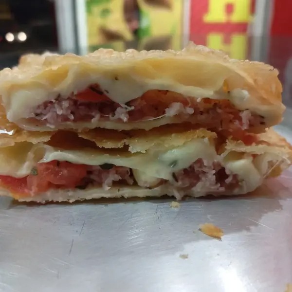 PASTEL RECHEADO COM MUÇARELA, PRESUNTO, TOMATE PICADO E ORÉGANO