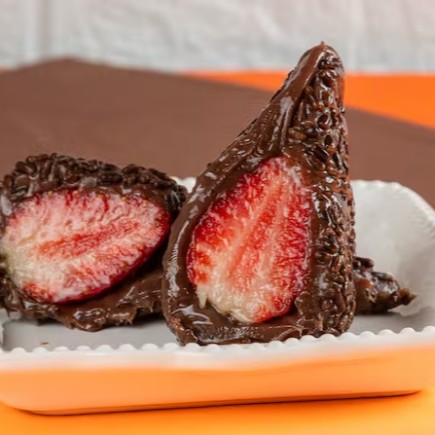 Massa da Coxinha feita com brigadeiro preto ao leite (clássico que funciona Demais) e recheada com morango (morango do Dia tá?) e coberta por granulado. São cerca de 110g de pura gostosura.