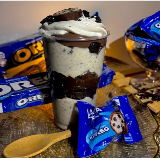 Camadas de creme de Ninho com biscoitos Oreo, brownies, brigadeiro, chantilly e bombom Oreo no topo.