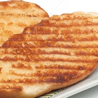 Duas belas partes de um pão francês, com manteiga e passado na chapa. Clássico das padarias.  Foto meramente ilustrativa.