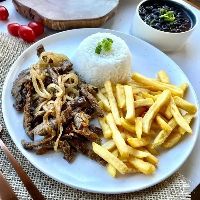 Iscas de Alcatra Acebolado com Fritas acompanhado de delicioso arroz branco soltinho, farofa da Chef e feijão com sabor de casa. (peso aprox. 650g)***Imagem Ilustrativa. Delicia de almoço.  Esperamos que você tenha uma ótima experiência com a gente.
