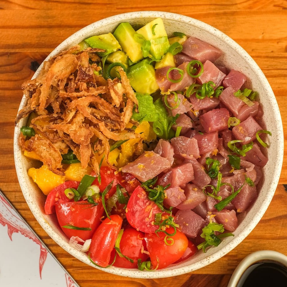 Base de arroz gohan temperado com gergelim, cubos de atum, tomate cereja, manga, sunomono, abacate, cebola crispy, finalizado com raspa de limão siciliano e cebolinha. Acompanha molho havaiano.
