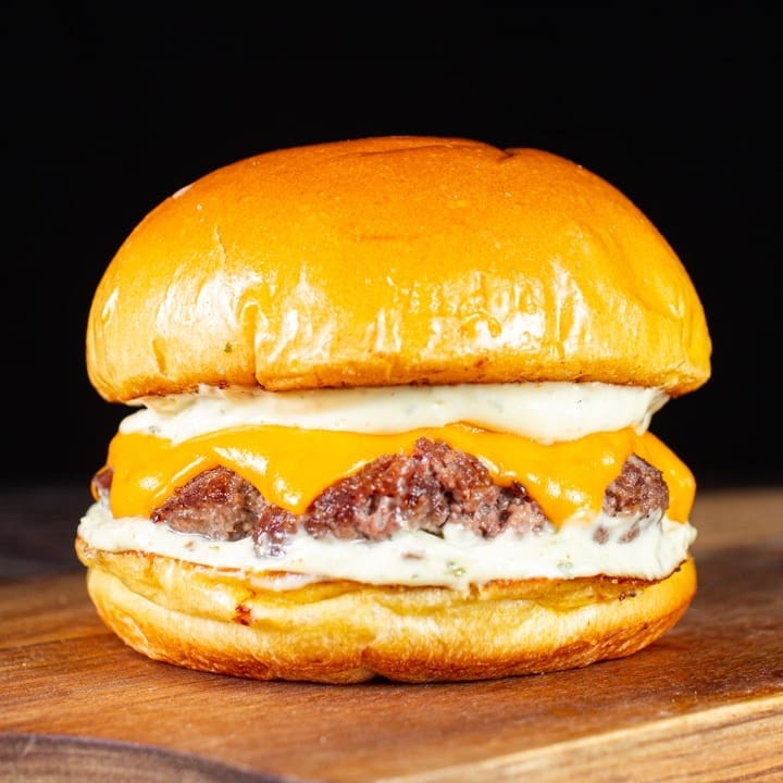 Delicioso Blend de 120g, com fatias de queijo cheddar + a nossa classíca e saborosa maionese verde da casa no pão brioche selado na manteiga.