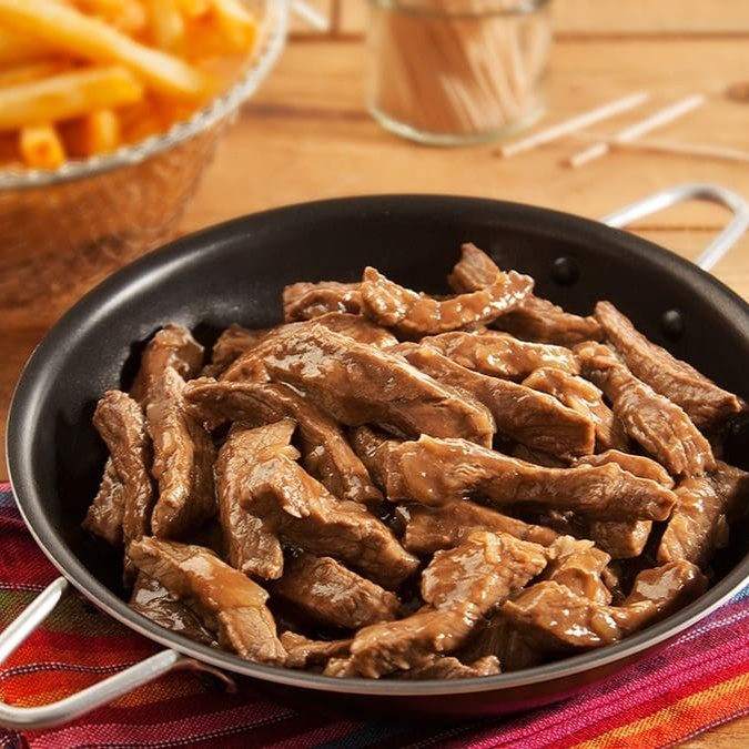 Tiras de Alcatra fritas na chapa. Temperadas na medida certa fica uma delícia, acompanhadas de feijão preto, arroz  farofa de bacon e batatas fritas. Serve muito bem uma pessoa.  . Refeição servida em uma marmita redonda de 750ml