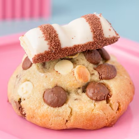 Deliciosa massa de cookie feito com manteiga de verdade com gotas de chocolate ao leite e gotas de chocolate branco, recheado com creme de Kinder Bueno White e finalizado com pedaços de Kinder Bueno White.