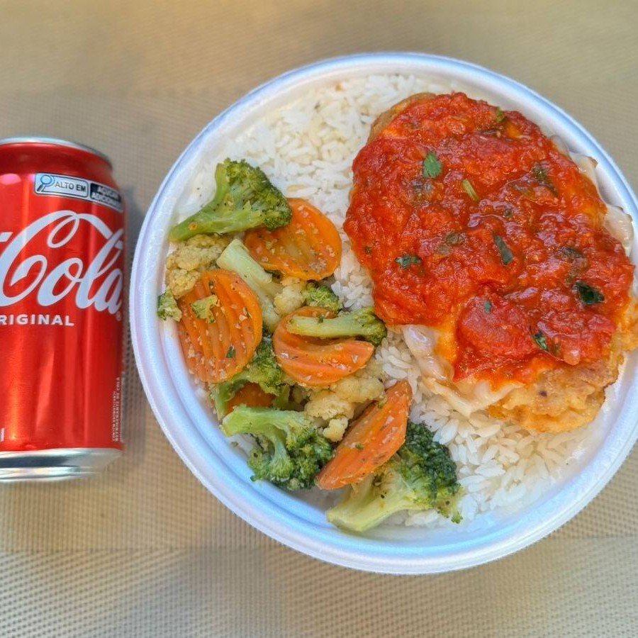 Marmita com delicioso filé de frango parmegiana (empanado na massa crocante coberto com molho de tomates e queijo) acompanhado de arroz branco e mix de legumes. Acompanha refrigerante lata Coca Cola 350ml bem gelada. Marmita indicada para 01 pessoa.