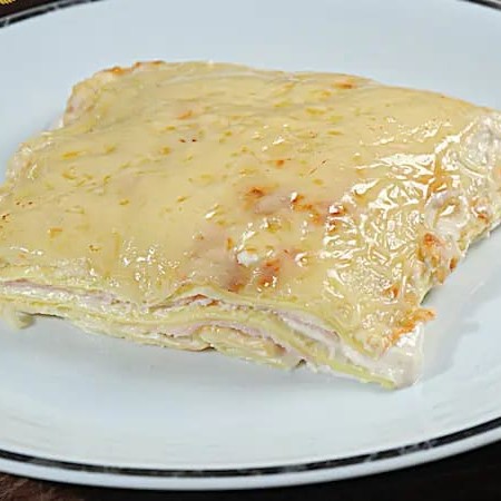 Apresentamos nossa Lasanha de Queijo e Presunto aos 3 Queijos, da categoria 'Lasanhas Artesanais'. Este prato é uma experiência gastronômica única, preparado com delicada massa artesanal, alternada por camadas de suculento presunto e queijo derretido, que se fundem em um sabor irresistível. A magia acontece quando esta combinação é envolvida por um molho sofisticado, feito à base dos queijos gorgo