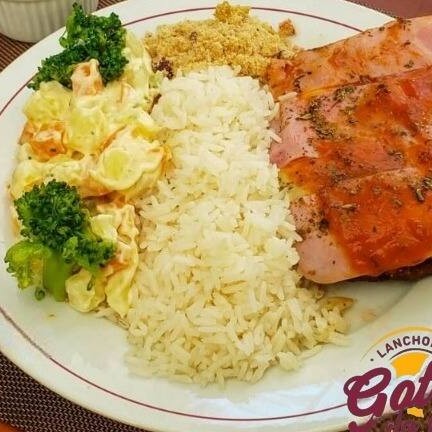 "Saboroso Contra Filé à Parmigiana feito ""no capricho"", acompanhado de arroz, feijão, farofa e um complemento Grátis."