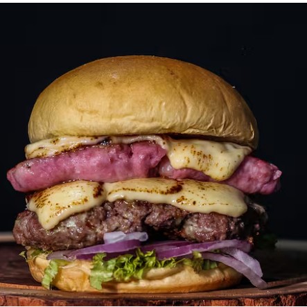 Pão de brioche, carne de 150 gramas, 100 gramas de linguiça suina, queijo coalho, alface americano e cebola roxa.