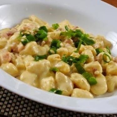 Descubra o encanto do nosso Gnocchi ao Molho Carbonara. Saboreie a harmonia perfeita de um molho branco requintado, enriquecido com o sabor intenso do parmesão e a suavidade envolvente da muçarela. O bacon acrescenta uma pitada de ousadia, enquanto o creme de leite finaliza este prato, conferindo-lhe uma textura aveludada. Com 500g, esta obra-prima da culinária italiana é um dos nossos Nhoques Cam