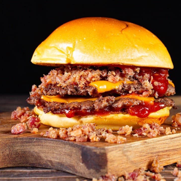 Delicioso smash duplo bacon feito com 2x blend artesanal de 80g smashado + queijo cheddar derretido, farofa de bacon e pão brioche selado na manteiga.