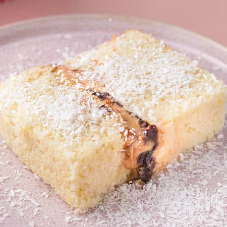 Pensa num bolo que traz a nostalgia das festinhas dos anos 90? Nossa versão do Bolo Gelado Olho de Sogra tem gostinho de infância e nos remete as melhores lembranças. Essa combinação é sucesso! Bolo pão de ló baunilha, bem molhadinho, recheado com doce de leite, ameixas e beijinho de coco.