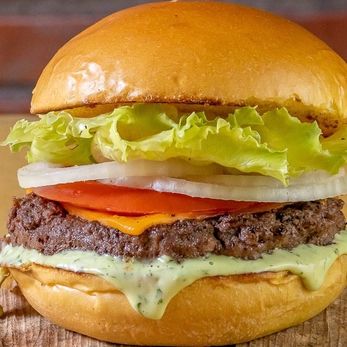 Pão de brioche, Blend Angus 160g, Queijo Cheddar Polenghi, Salada Fresca (alface, tomate e cebola) e Maionese Verde Temperada