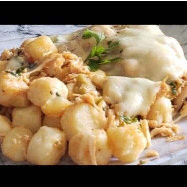 Delicie-se com o nosso Nhoque de Frango ao Molho Branco, da categoria Nhoques Artesanais (Batata Asterix). Este prato, cuidadosamente elaborado, apresenta o nhoque envolto em suculento frango desfiado, generosamente regado com um sublime Molho Bechamel enriquecido com Provolone. Para finalizar, uma camada de queijo gratinado dourado e crocante cobre o prato, proporcionando uma experiência gastronô