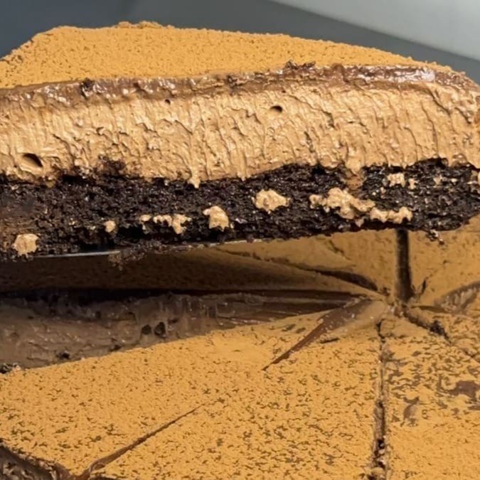Uma fatia de Brownie Mousse de Chocolate é pura tentação! Base do bendito brownie macio e irresistível, seguido de uma mousse de chocolate blend cremosa que derrete na boca. A ganache de chocolate meio amargo traz um toque profundo, enquanto o cacau em pó finaliza com aquele gostinho perfeito de chocolate que não sai da mente. Uma verdadeira explosão de prazer a cada pedaço!