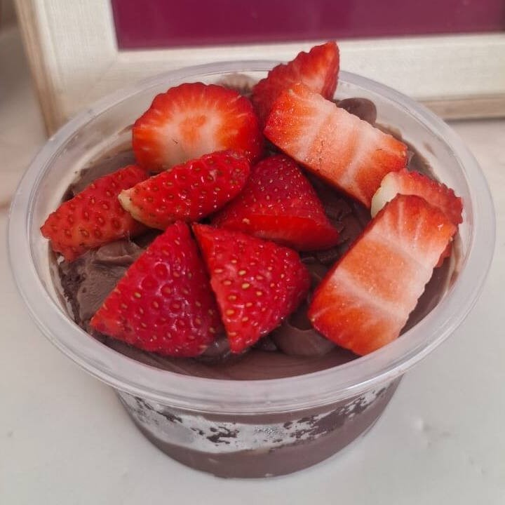 Bolo no pote de chocolate com morangos picados, brigadeiro de chocolate e massa de chocolate. Nossos bolos pesam em média 200g, a embalagem poderá variar de acordo com a disponibilidade no fornecedor, mas sempre terão essa quantidade independente do formato de embalagem disponível.