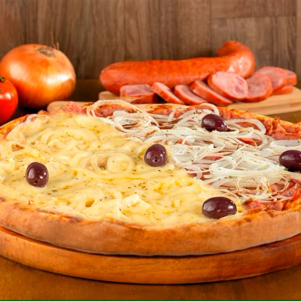 Pizza 1/2 Calabresa 1/2 Portuguesa (8 fatias): metade com calabresa fatiada, cebola, orégano e mussarela derretida; a outra metade com milho e erviha ,palmito ovos, cebola, azeitonas e mussarela. Uma combinação clássica que agrada a todos!