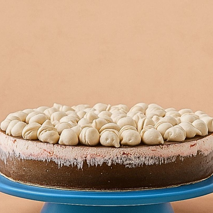 Esta delícia, de 27 cm, é composta por uma base de biscoitos de chocolate, coroada com uma camada generosa de creme de avelã. Em seguida é recheada com camadas de morangos frescos, proporcionando um equilíbrio perfeito entre o doce e o cítrico. Destacamos a presença do nosso chantilly, complementado por uma generosa quantidade de cacau finamente polvilhado sob suspiros delicados que derretem na boca. Esta torta exuberante tem a capacidade de servir 20 fatias moderadas, tornando-se a escolha perfeita para compartilhar momentos especiais.