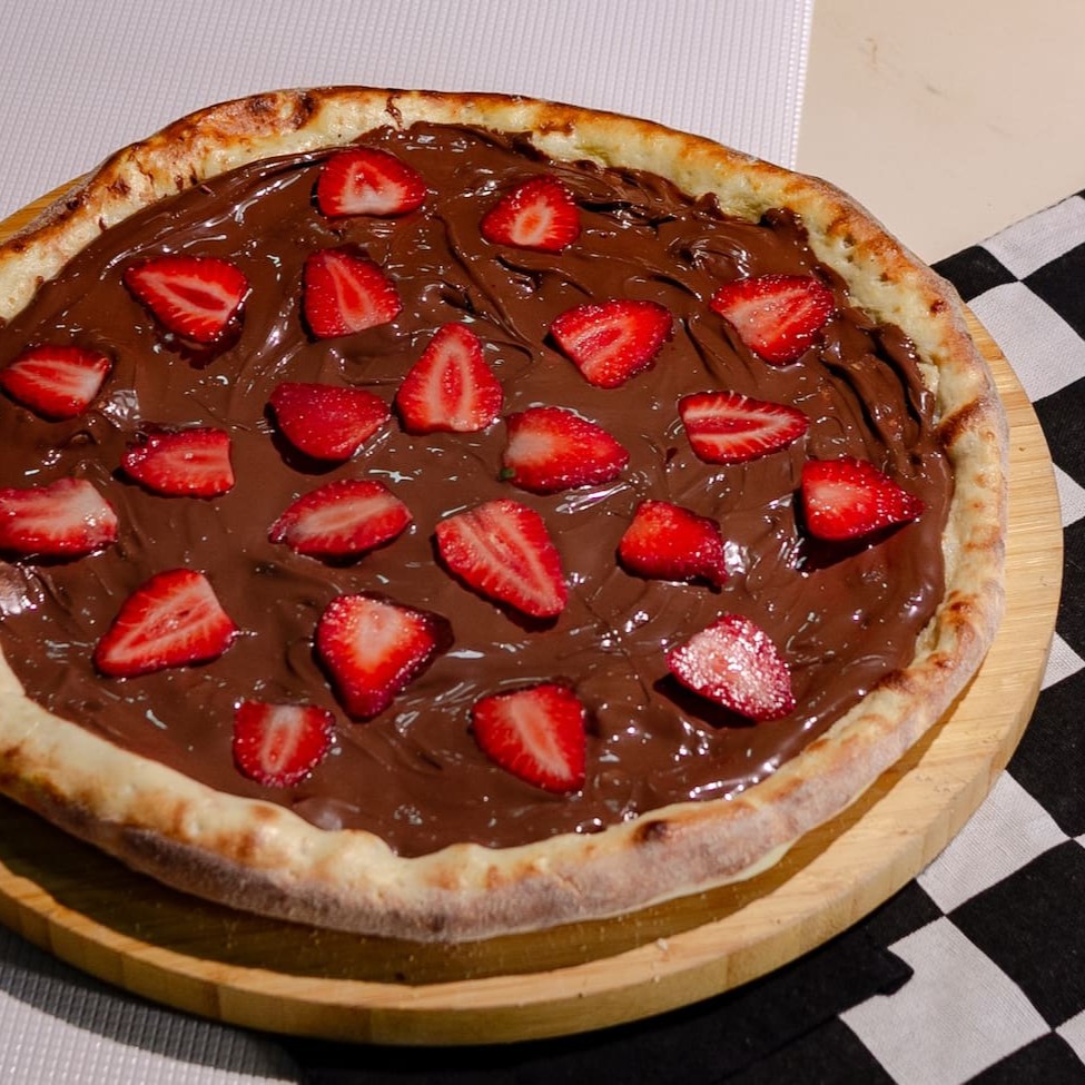 Essa Pizza Despensa comentários. Com uma camada Generosa de Nutella Jamais visto. Você experimenta a melhor pizza doce da Terra. Com  Creme de Leite, camada Generosa de Nutella e Morango Fresco (tudo Original). Brotão (25cm)