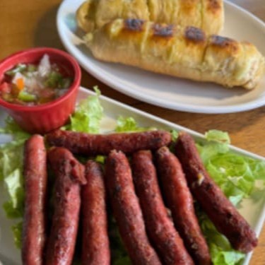 Linguiça de costela é acompanhada por nosso famoso pão de alho, que agrega um sabor único e marcante à experiência.