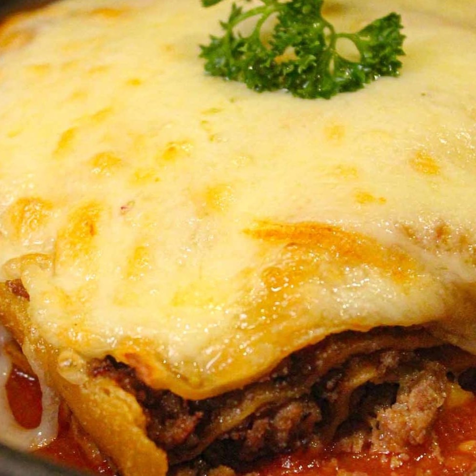 Ragu de carne, molho de tomate, parmesão e mozzarela gratinada ao forno