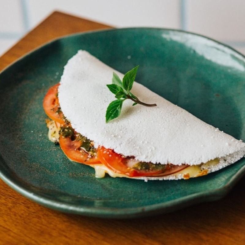 Inspirada nos sabores clássicos da pizza tradicional, essa tapioca é recheada com molho de tomate caseiro, mussarela derretida, calabresa fatiada em rodelas, tomate fresco, cebola, orégano aromático e finalizada com manteiga de garrafa. Uma combinação saborosa e prática que une o melhor da culinária regional com a paixão pelo sabor italiano.