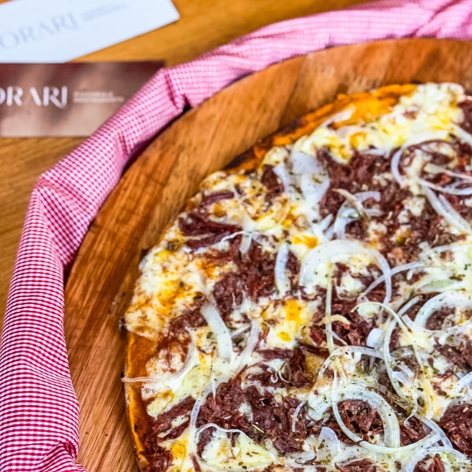 Molho da casa, mussarela, carne seca, cebola e orégano.