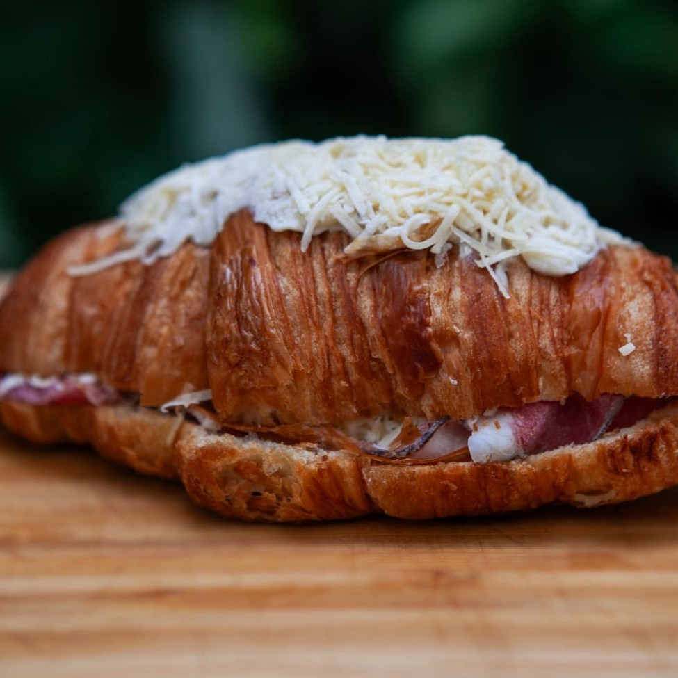 Croissant recheado com creme béchamel, pastrami, molho pesto e mix de queijos. Semi pronto, basta aquecer poucos minutos em forno com temperatura baixa e se deliciar. (produto congelado)