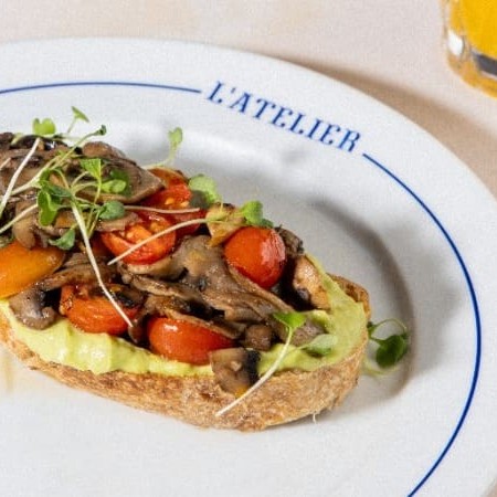 Pão de Sourdough, pasta de avocado com toque de limão siciliano, cogumelos salteados, picles de cebola e tomate confit.