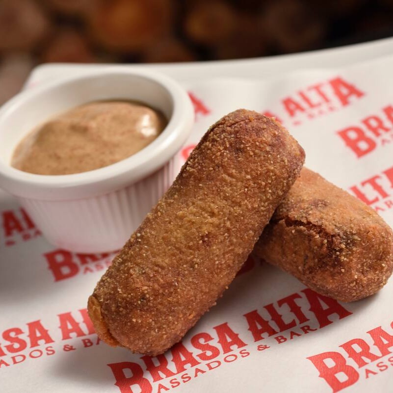 Croquete artesanal feito com costela bovina desfiada, cozida lentamente até ficar macia e suculenta. Temperado com ervas selecionadas e envolto numa casquinha crocante e dourada.