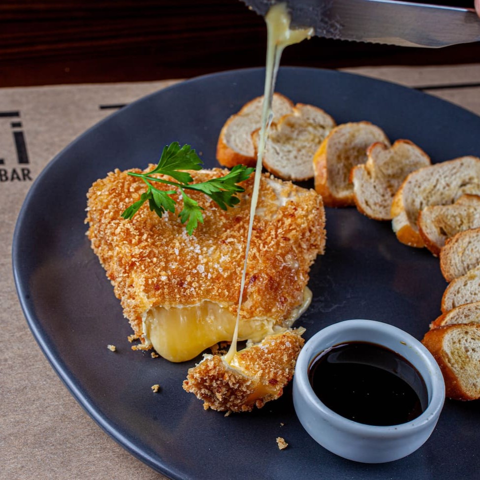 Queijo brie empanado e super crocante, acompanhado de torradinhas e melado de cana.